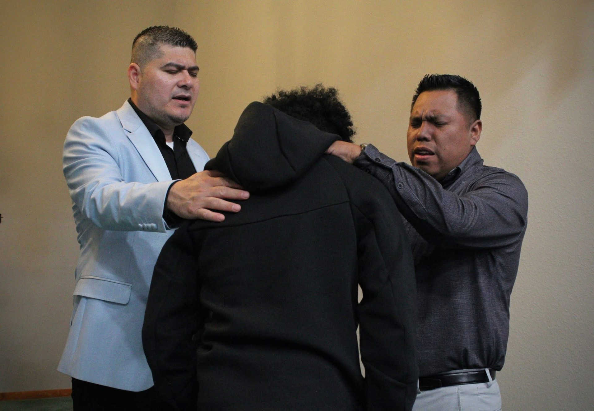 Hombres orando por una persona