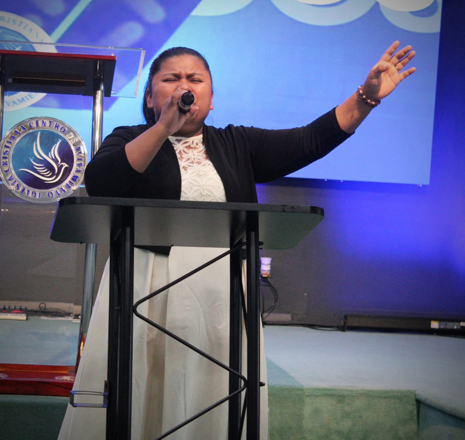 Mujer cantando durante un servicio de adoración